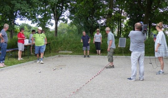 Boule-Spieler Heinrich Körner mitten im Wettkampf vor laufender Kamera, kritisch beobachtet von den Mitspielern Hans Vierl, Heidi Lindner, Wast Mitterer, Christa Ertl und Peter Schreyer (von links)